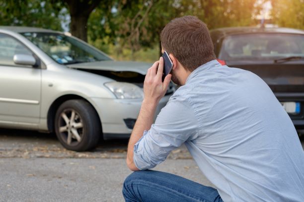 Man calling insurance company after car accident